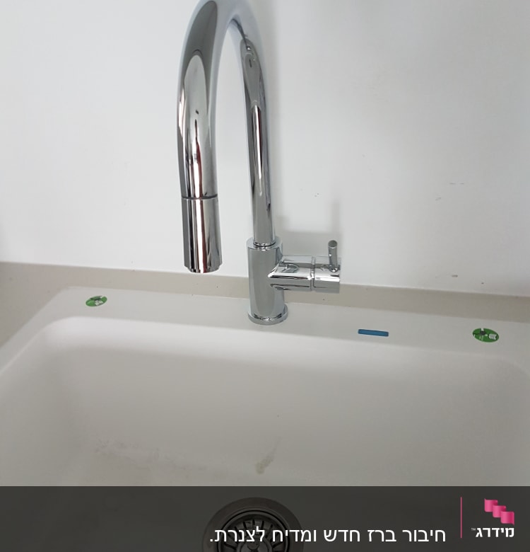 ברז נירוסטה מעל כיור לבן עם ניקוז